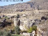 Can Aprisco. Muro de piedra rabe y al pie de la pared de piedra una alberca